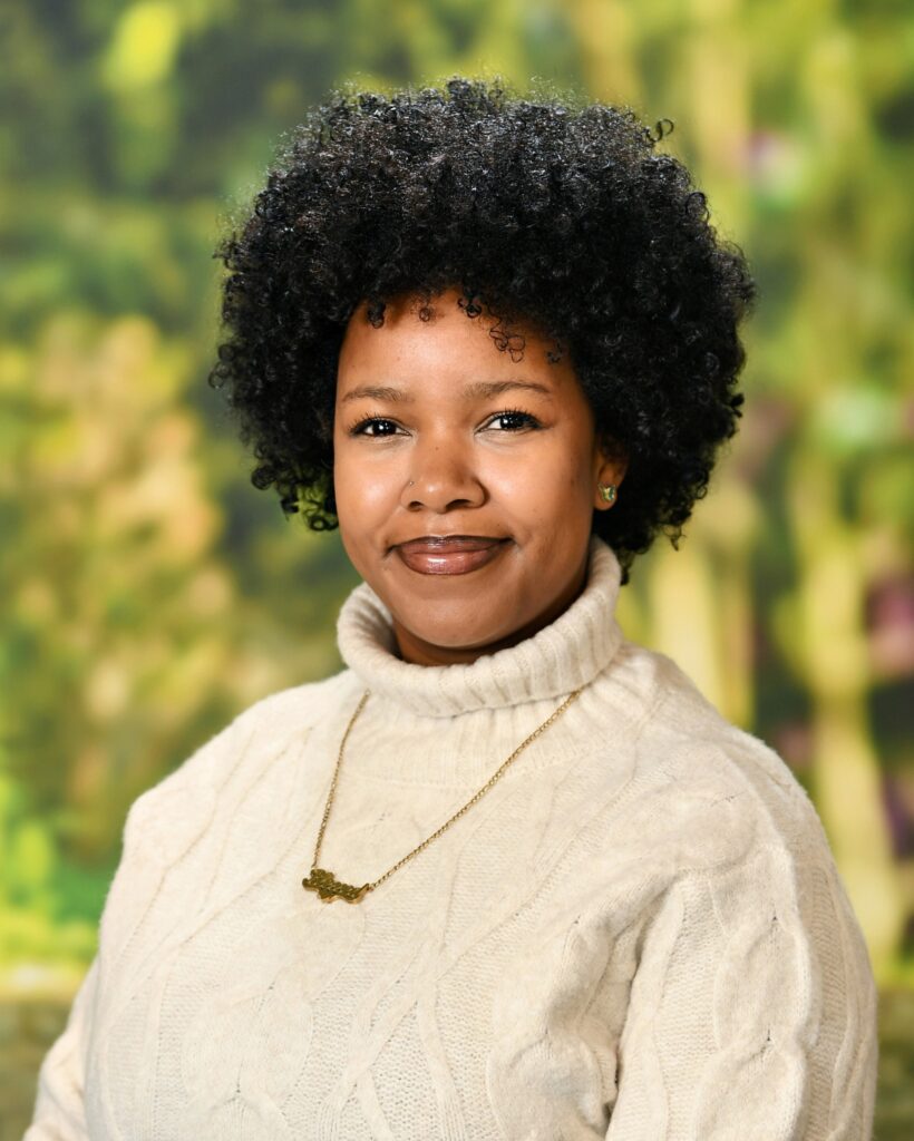 Karen Johnson smiling in front of a blurred nature background.