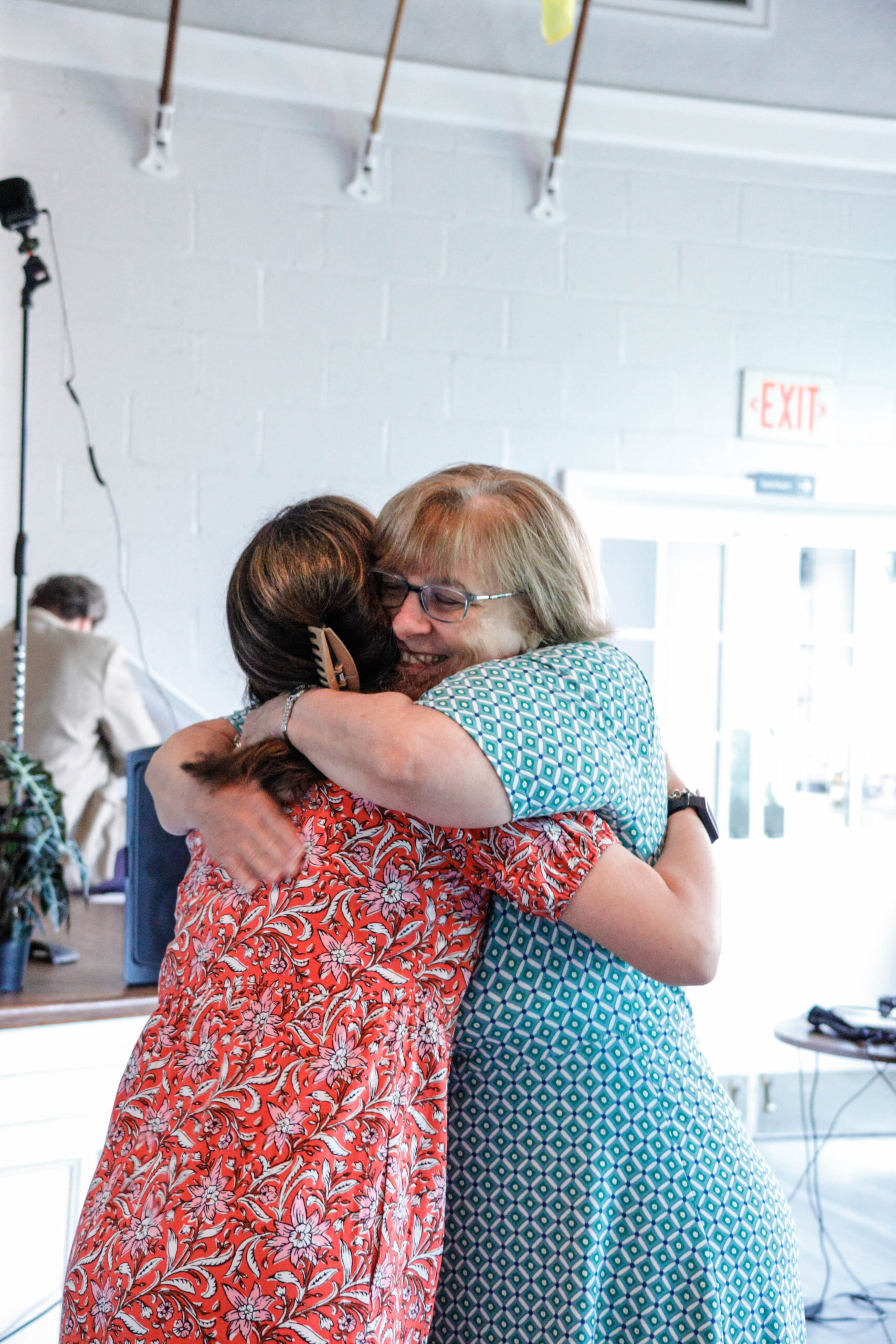 Julie passionately hugging a TSS parent at the 2025 Fundraising Breakfast after announcing her retirement.