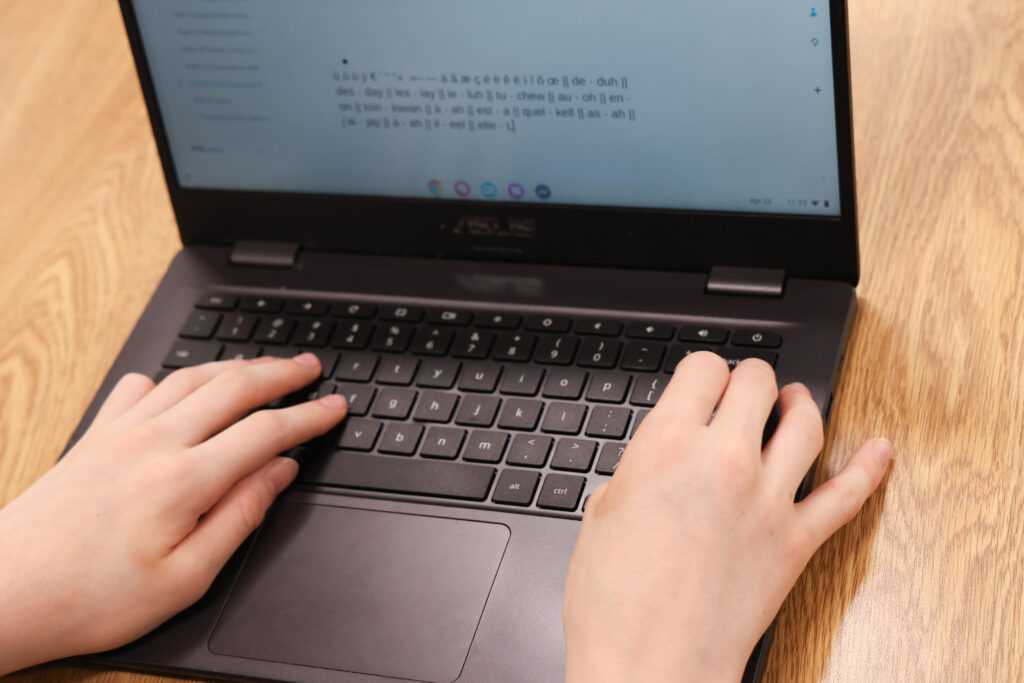 Student typing on computer in a foreign language