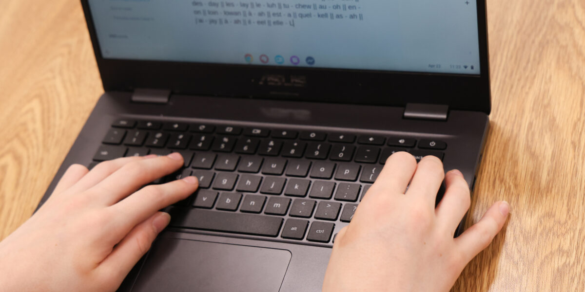 Student typing on computer in a foreign language