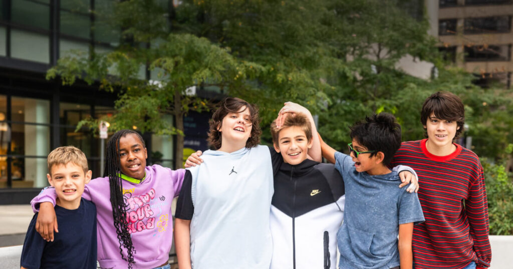 Middle School students at The Sycamore School with their arms around each other and smiling