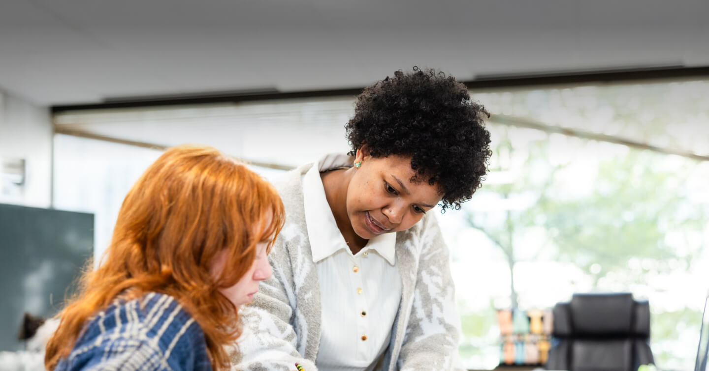 Teacher at The Sycamore School looking over a student's work