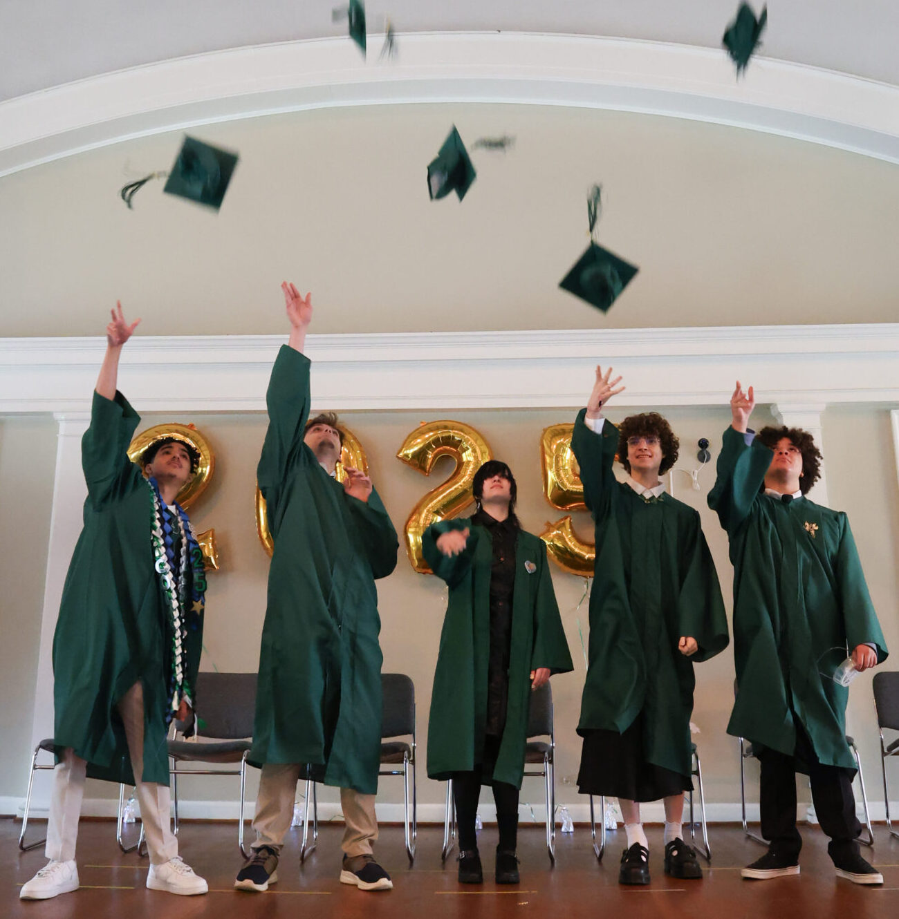 20250605_Graduation_Community_Throwing_Caps_Tassles 2025 graduates excitedly throwing their caps in the air after the ceramony.